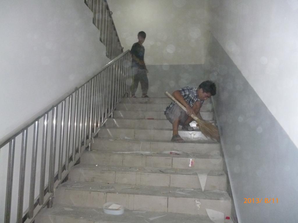 工人师傅正在认真清理楼梯踏步，为安装楼梯踏步做准备