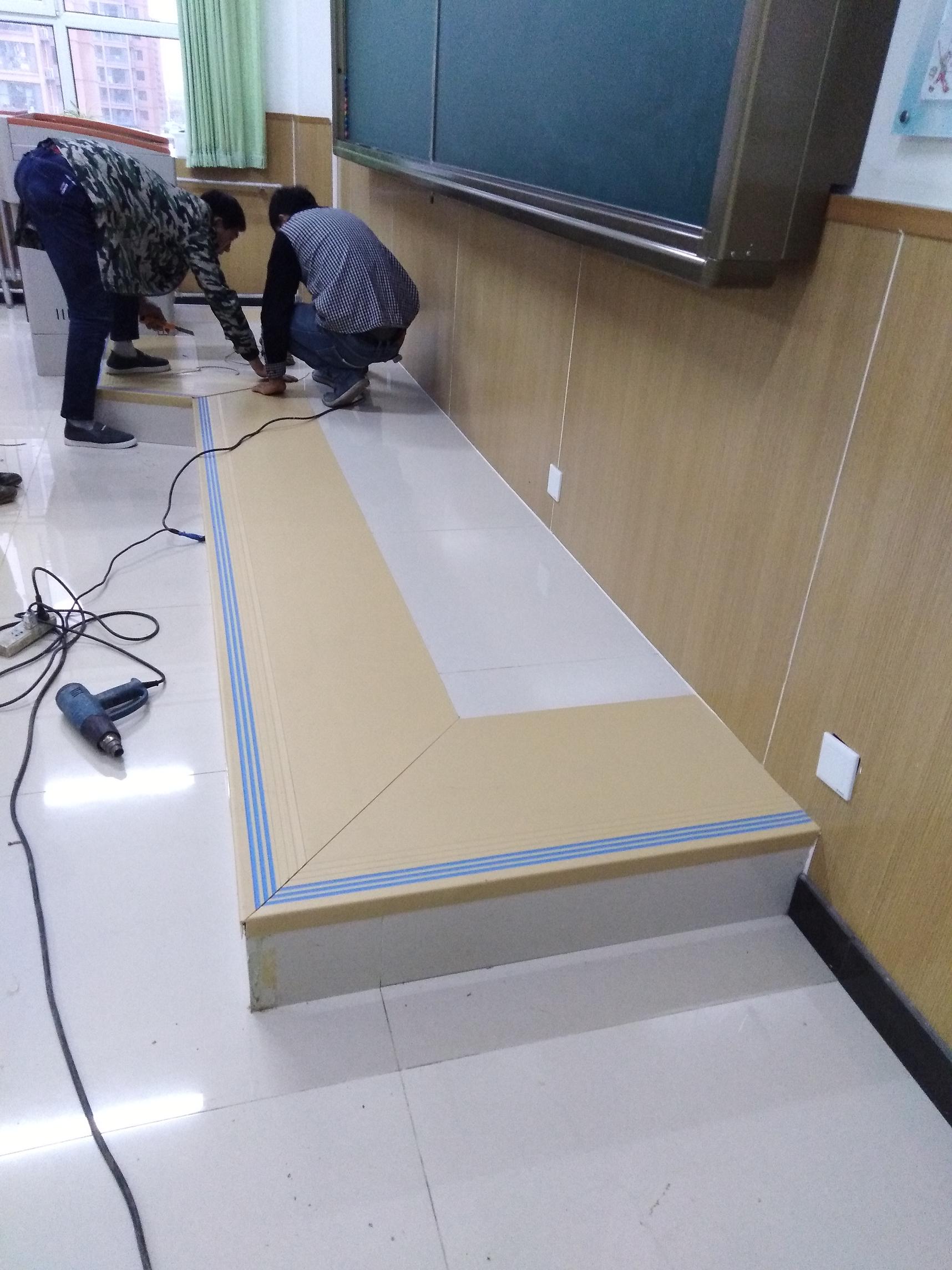 工人师傅正在安装讲台的PVC地板