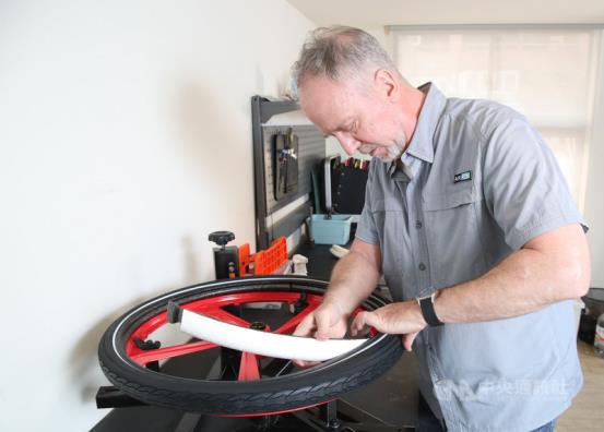 艾逸豐創辦人麥必得可在5分鐘內，快速完成換拆自行車胎的填充物。中央社記者張新偉攝 110年4月2日