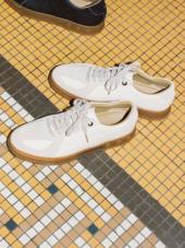 A pair of white shoes on a yellow and black checkered floor

Description automatically generated with low confidence