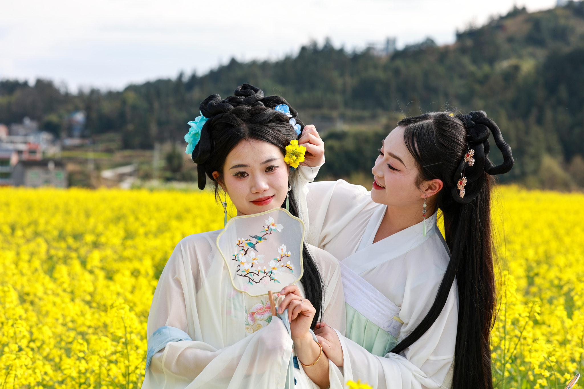 Hanfu enthusiasts immerse themselves in the golden rapeseed flower fields of Sansui County, Guizhou Province, March 19, 2025. /CFP